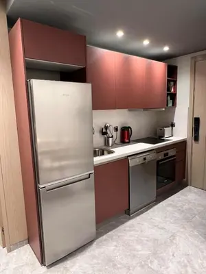 a kitchen with stainless steel appliances and red cabinets at Appartement à Casablanca Ferme bretonne OCP à 5min du CFC in Casablanca