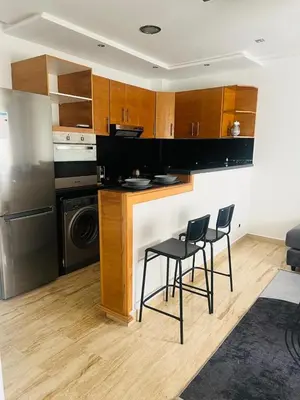 a kitchen with two chairs and a counter with a dishwasher at Appartement centre de casablanca in Casablanca