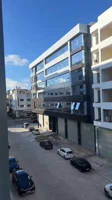 a parking lot with cars parked in front of a building at Studio de luxe in Casablanca