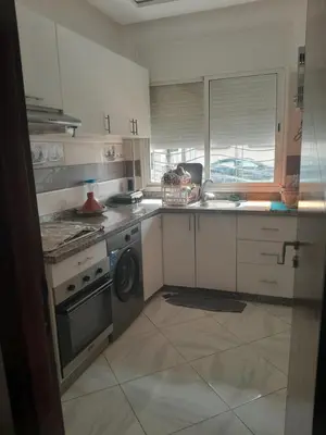 a kitchen with a stove and a washing machine at Dahomy bouzni9a in Bouznika