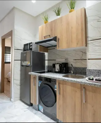 a kitchen with a sink and a washing machine at Luxury & sweet studio apartment with swimming pool in Aïn Harrouda