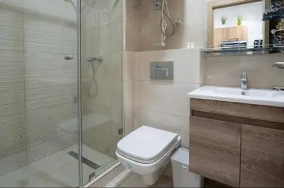 a bathroom with a shower and a toilet and a sink at Luxury & sweet studio apartment with swimming pool in Aïn Harrouda