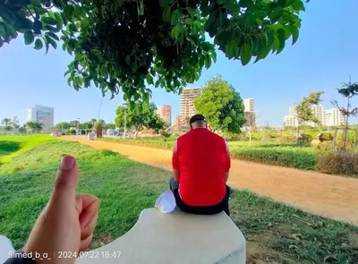 a person taking a picture of a man sitting on a rock at Luxury & sweet studio apartment with swimming pool in Aïn Harrouda