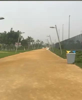a dirt road with street lights and a white bucket at Luxury & sweet studio apartment with swimming pool in Aïn Harrouda