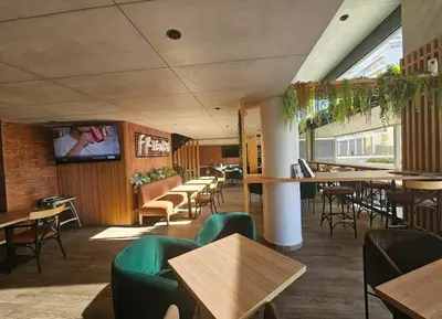 a restaurant with tables and chairs and a flat screen tv at Luxury & sweet studio apartment with swimming pool in Aïn Harrouda