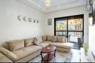 a living room with a couch and a table at Luxury & sweet studio apartment with swimming pool in Aïn Harrouda