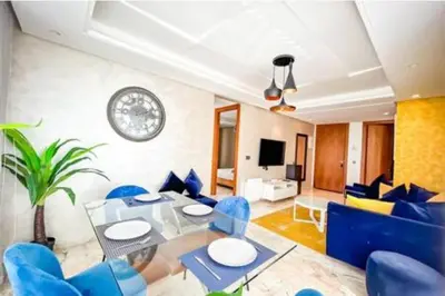 a living room with blue chairs and a table at Résidence Saphir Luxury apartment with terrace in Racine in Casablanca