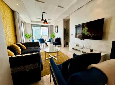 a living room with two couches and a table at Résidence Saphir Luxury apartment with terrace in Racine in Casablanca