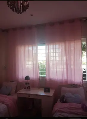 a bedroom with pink curtains and a desk and two beds at Rabat prestigia hayriad in Rabat