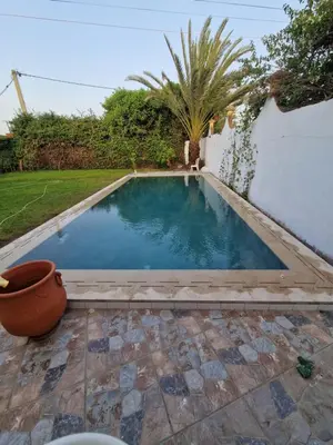 a small swimming pool in a yard with a wall at Villa spacieuse avec piscine proche aéroport Mohamed V in Nouaseur