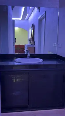 a bathroom counter with a sink and a mirror at Spacious apartment in Settat