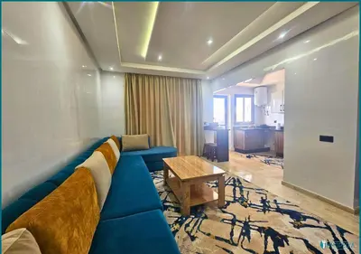 a living room with a blue couch and a table at Une petite parenthèse marine in Mansouria