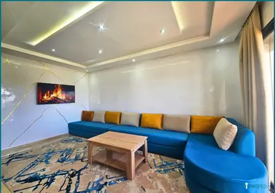 a living room with a blue couch and a table at Une petite parenthèse marine in Mansouria