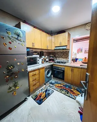 a kitchen with wooden cabinets and a stainless steel refrigerator at Élégance et Sérénité au Cœur de Casablanca in Casablanca