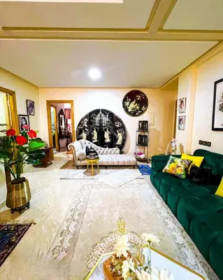 a living room with a green couch and a table at Élégance et Sérénité au Cœur de Casablanca in Casablanca