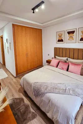 a bedroom with a large bed with pink pillows at Appartement de Luxe - Gare Rabat Agdal in Rabat