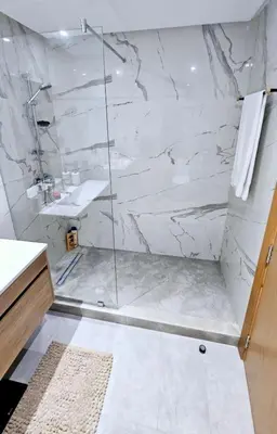 a bathroom with a shower with a glass door at Appartement de Luxe - Gare Rabat Agdal in Rabat