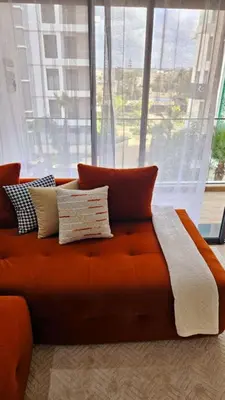 an orange couch in front of a large window at Appartement de Luxe - Gare Rabat Agdal in Rabat