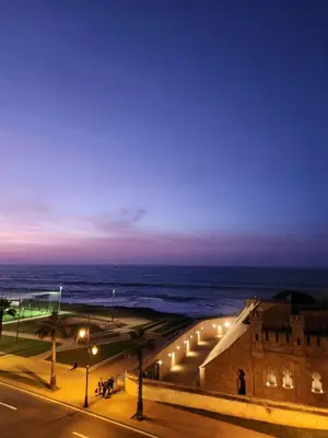 a view of a street with the ocean at night at Joumaira appartement Beach in Rabat