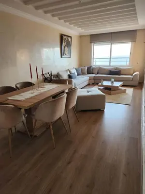 a living room with a table and a couch at Joumaira appartement Beach in Rabat
