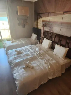 a bedroom with two large beds with white sheets at Joumaira appartement Beach in Rabat