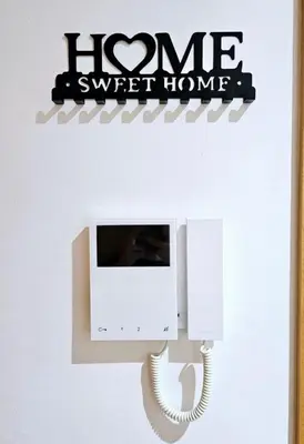 a phone on a wall with a home sweet home sign at Cosy Appartement Rabat Agdal in Rabat