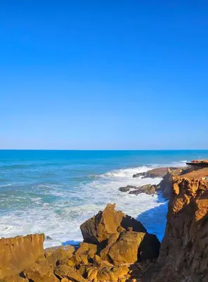 a view of the ocean from a rocky beach at Cosy Appartement Rabat Agdal in Rabat