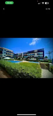 a picture of a building with a pool in front of it at Mark in Temara