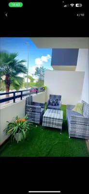 a balcony with three chairs and a potted plant at Mark in Temara