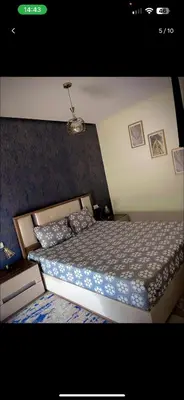 a bedroom with a bed with a blue and white comforter at Mark in Temara