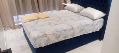 a bed with a blue headboard with a baby crib at Abbogroup Appartement 2 in Casablanca