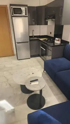 a kitchen with a blue couch and a table at Abbogroup Appartement 2 in Casablanca