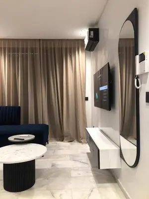 a living room with a blue couch and a tv at Abbogroup Appartement 2 in Casablanca