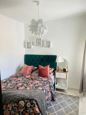 a bedroom with a bed with a green headboard at Jannat tamaris in Tamaris