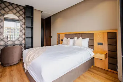 a bedroom with a large white bed and a chair at Urban Chic Suite Casablanca city centre - Parking Gym in Casablanca