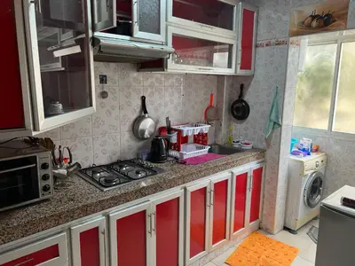 a kitchen with red and white cabinets and a stove at Appartement de luxe in Casablanca