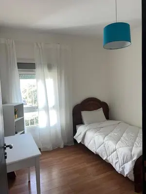 a bedroom with a white bed and a window at Spacious and stylish apartment near stadium Moulay Abdellah in Rabat