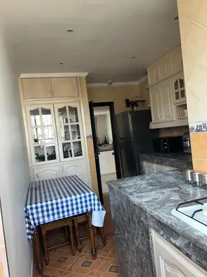 a kitchen with a table with a checkered counter top at Spacious and stylish apartment near stadium Moulay Abdellah in Rabat