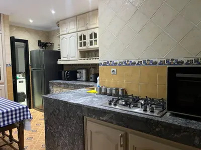 a kitchen with a stove and a refrigerator at Spacious and stylish apartment near stadium Moulay Abdellah in Rabat