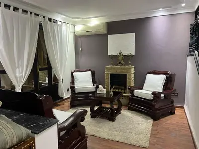 a living room with two chairs and a fireplace at Spacious and stylish apartment near stadium Moulay Abdellah in Rabat
