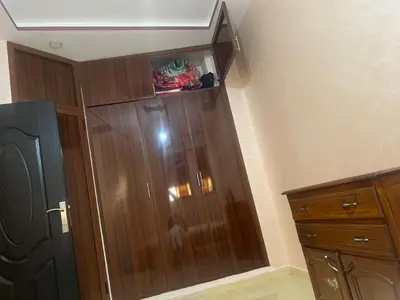 a large wooden cabinet in the corner of a room at Appartement a settat in Settat