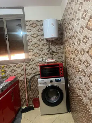 a washing machine sitting in a bathroom with aperature at Appartement a settat in Settat