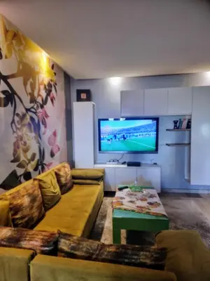 a living room with a couch and a flat screen tv at Les perles de tamaris in Casablanca