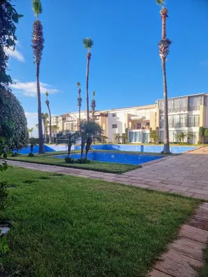 a resort with palm trees and a swimming pool at Les perles de tamaris in Casablanca