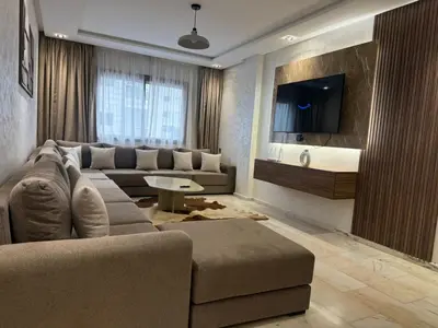 a living room with a couch and a tv at RÉSIDENCE LE BIjOU DE L'AGDAL in Rabat