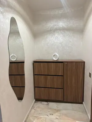 a bathroom with a wooden dresser and a mirror at RÉSIDENCE LE BIjOU DE L'AGDAL in Rabat
