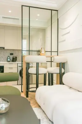 a living room with a table and stools at Résidence Claridge Racine in Casablanca