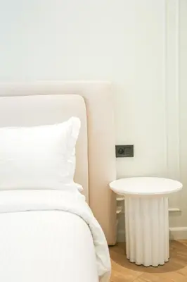 a white bed with a white table in a room at Résidence Claridge Racine in Casablanca