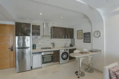 a kitchen with stainless steel appliances and a table at Résidence Eden - Maarif in Casablanca