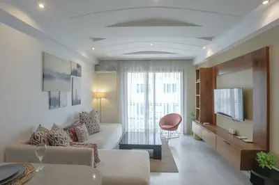a living room with a couch and a tv at Résidence Eden - Maarif in Casablanca